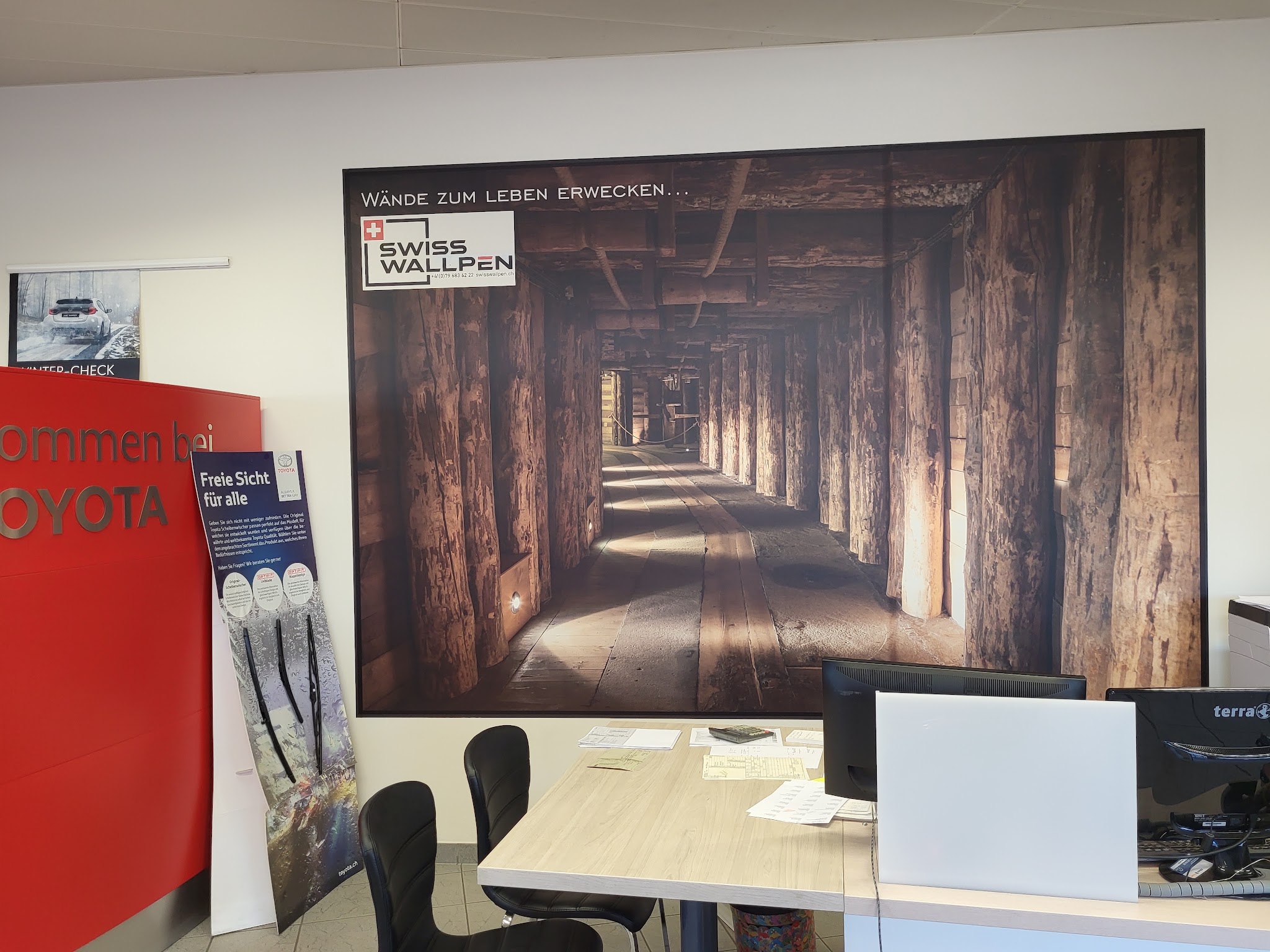Wanddruck eines Holzstollens in einem Autohaus-Wartebereich